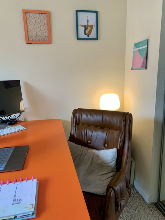 Cushy brown leather swivel chair behind orange desk