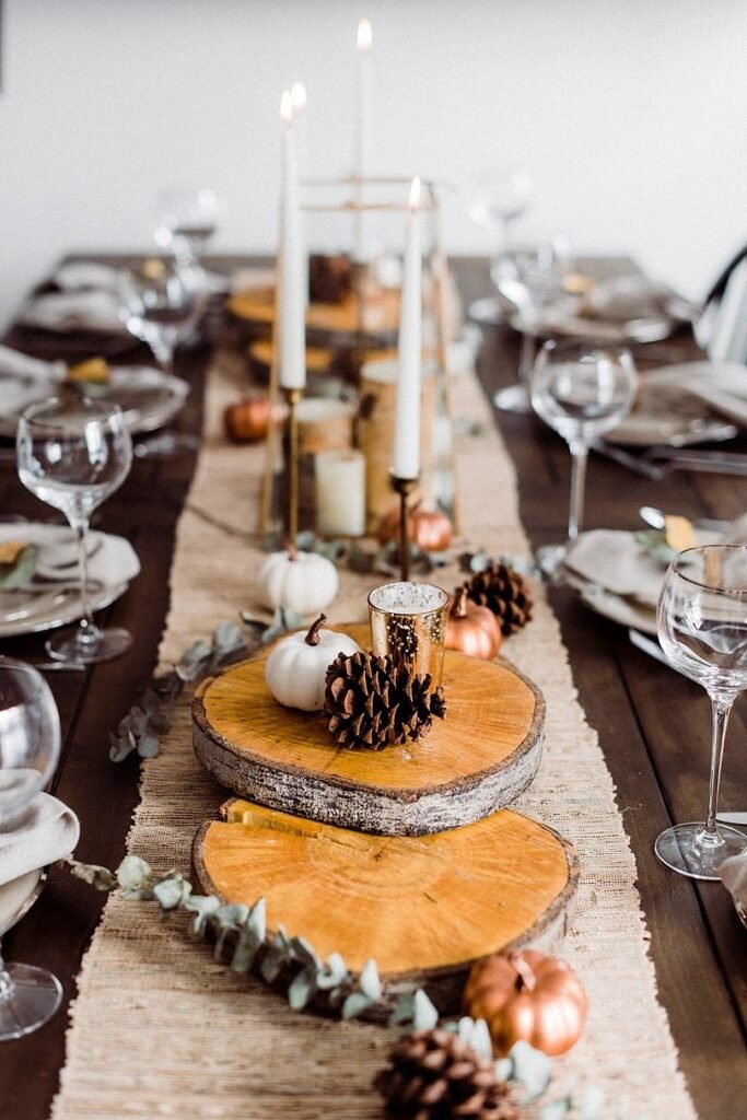 elegant rustic thanksgiving tablescape by joyfully growing. Wood stump centerpieces with pumpkins, candles, and pinecones