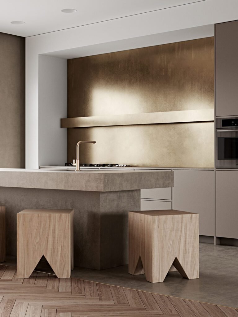Modern, minimalist kitchen with brushed gold backsplash, herringbone flooring, sculptural wooden stools, and a stone island.