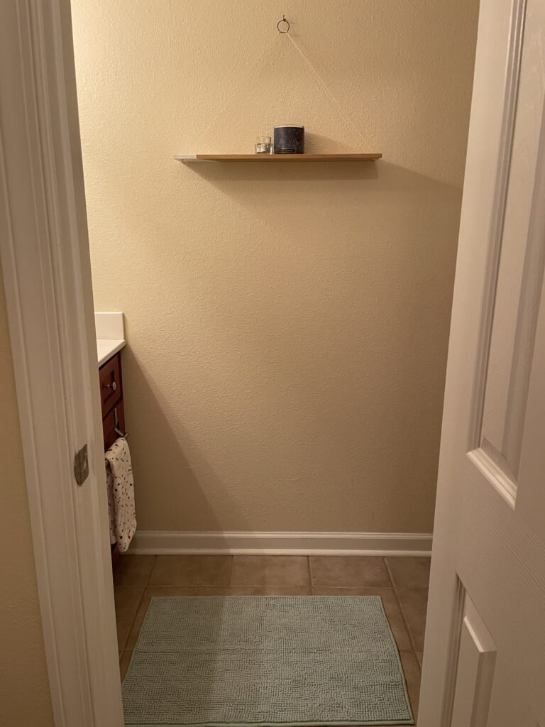 View of bathroom wall with DIY shelf