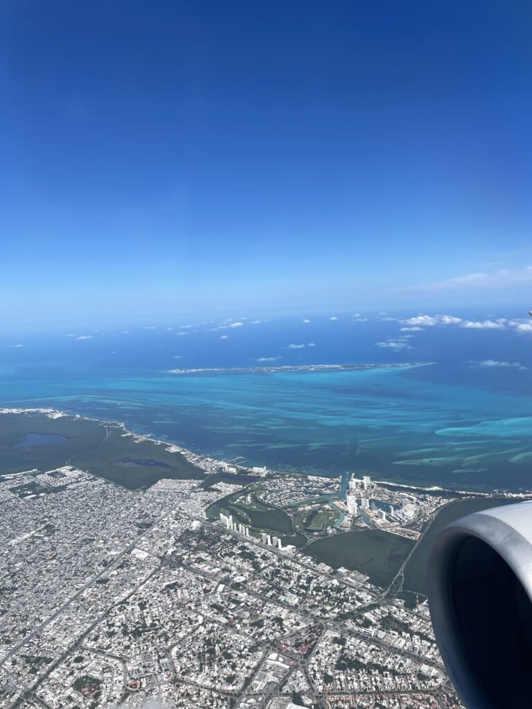 view from airplane of the Cancun coast with clear blue/aqua colored water