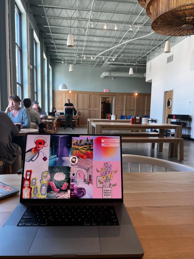 View of The Daily West Midtown behind a computer screen - ashy wood details and a very light sage green color on upper walls and ceiling