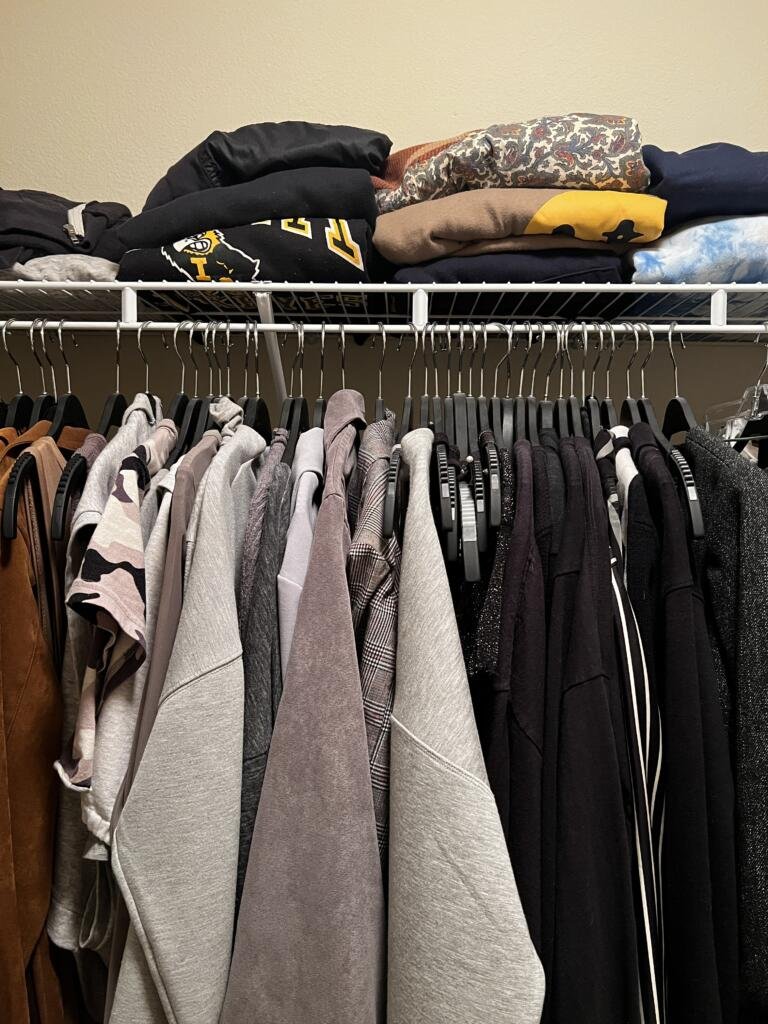 Color-coordinated closet with matching black and silver hangers 
