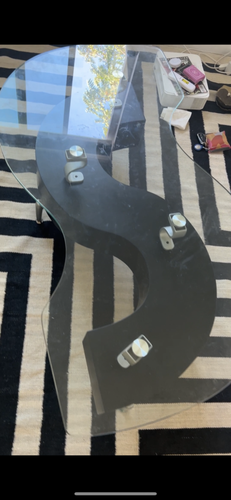black and clear glass s-shaped coffee table