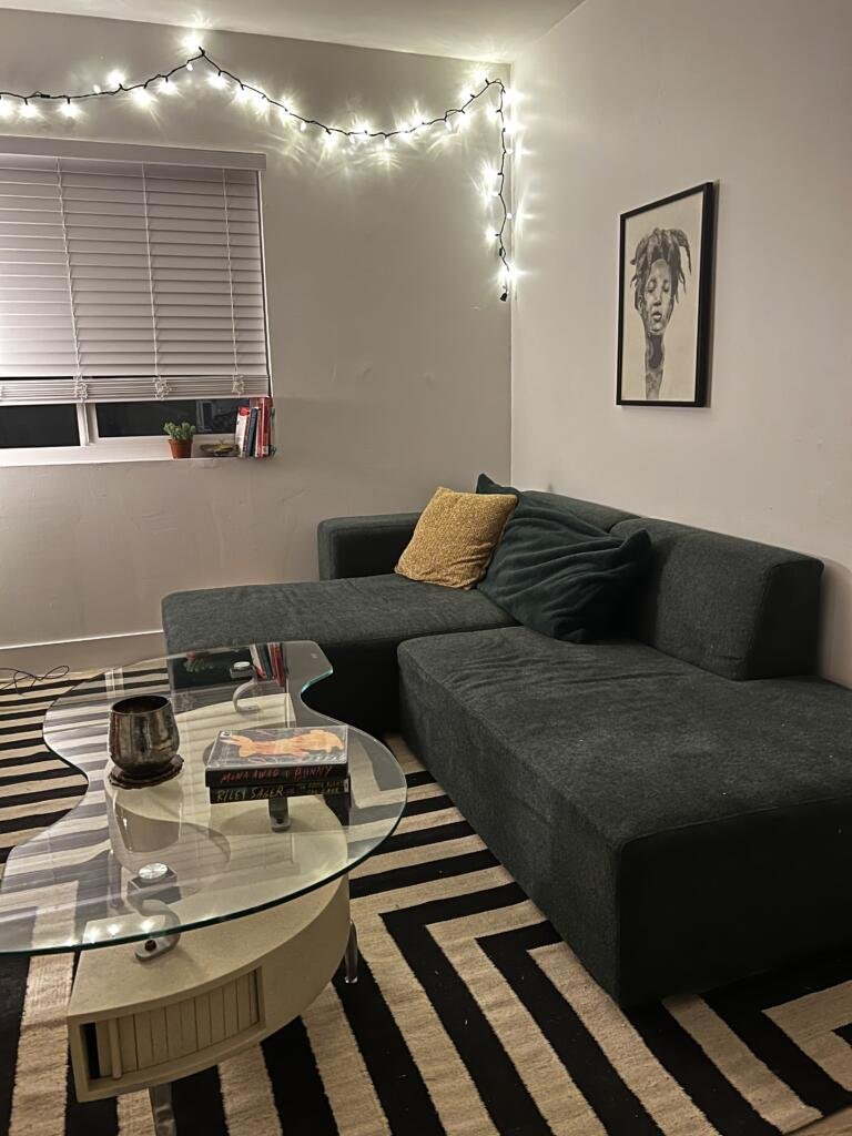 Floyd sectional couch in green in a small modern living room with a graphic black and white rug