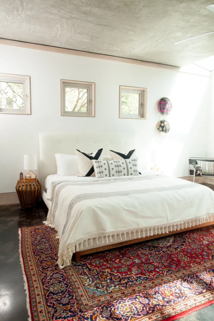 minimalist boho bedroom with a red boho rug